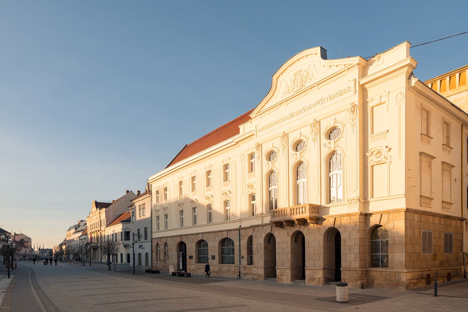 Divadlo Jána Palárika v Trnave, historická budova v klasicistickom štýle na pešej zóne v centre mesta, osvetlená podvečerným slnkom.