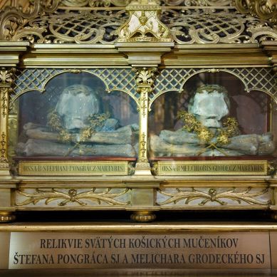 Relikvie dvoch z troch košických mučeníkov, svätého Štefana Pongráca SJ a svätého Melichara Grodeckého SJ, vystavené v ozdobnej sklenenej relikviári z pozláteného kovu v Kostole Najsvätejšej Trojice v Trnave. Relikvie sú uložené na zamatovom podklade a obklopené dekoratívnymi prvkami.